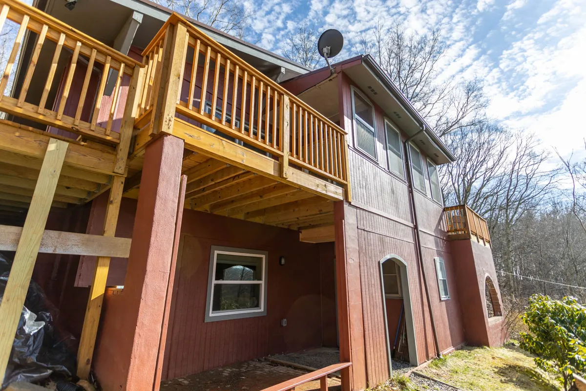 Featuring the chalet’s distinctive red exterior, expansive wooden balconies, and large windows, this image invites guests to picture themselves returning to a welcoming mountain retreat after exploring nearby towns. The balconies offer ample space for outdoor gatherings and enjoying sunset views with friends.